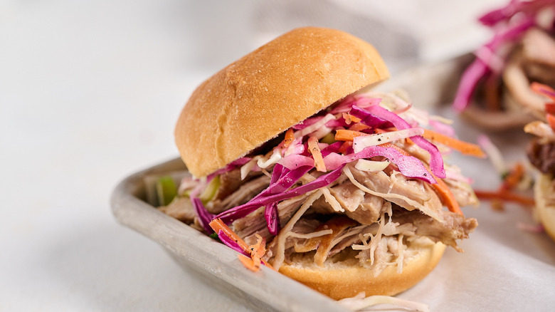 pulled pork sandwich with coleslaw on tray