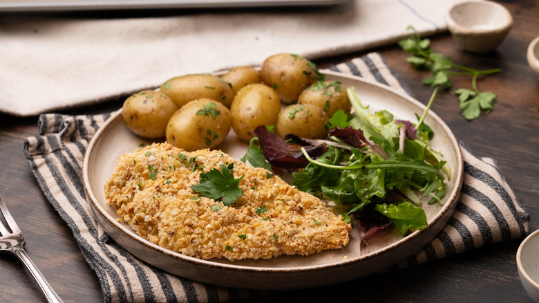 hazelnut crumb-coated chicken with potatoes and salad
