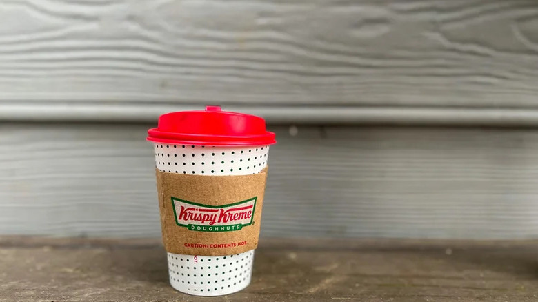 A cup of Krispy Kreme hot chocolate with a red lid