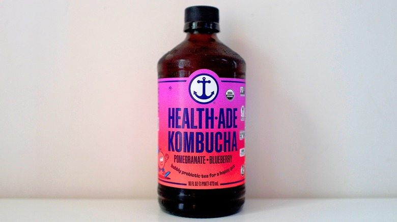 Bottle of Health-Ade Pomegranate Blueberry Kombucha on white table