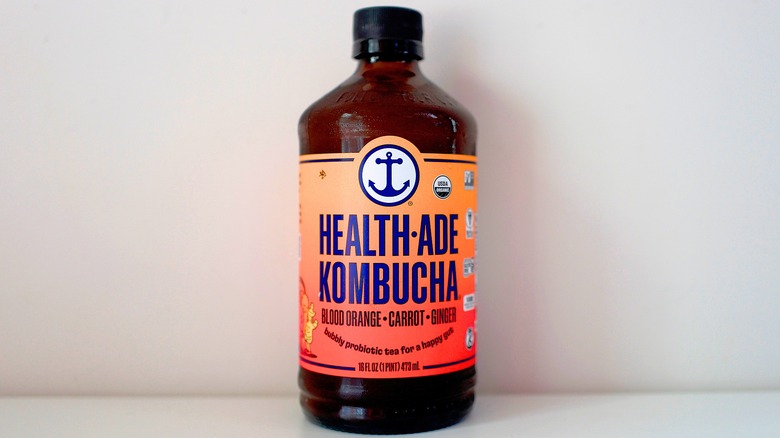 Bottle of Health-Ade Blood Orange Carrot Ginger Kombucha on white table