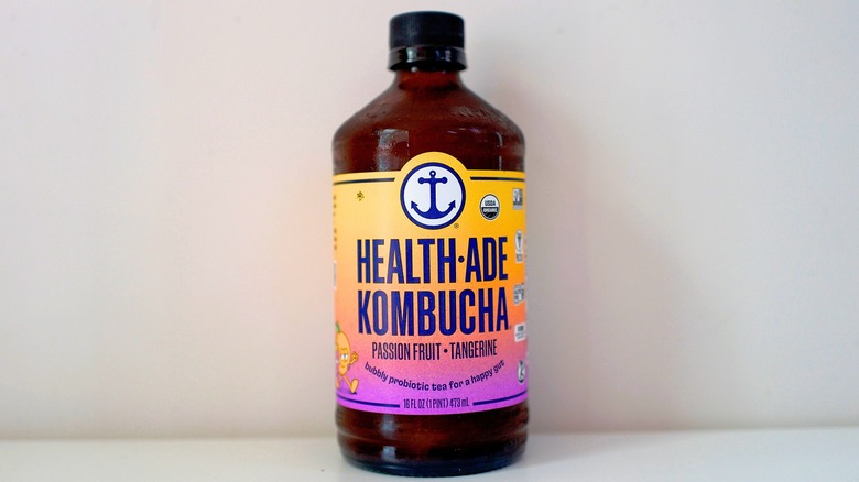 Bottle of Health-Ade Passionfruit Tangerine Kombucha on white table