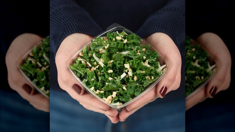 person holding container of Chick-fil-A kale crunch salad in their palms