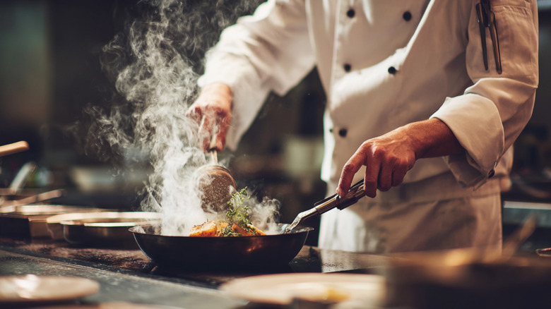 chef in kitchen cooking on stove