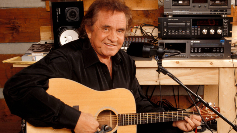 Johnny Cash performing with a guitar in a studio
