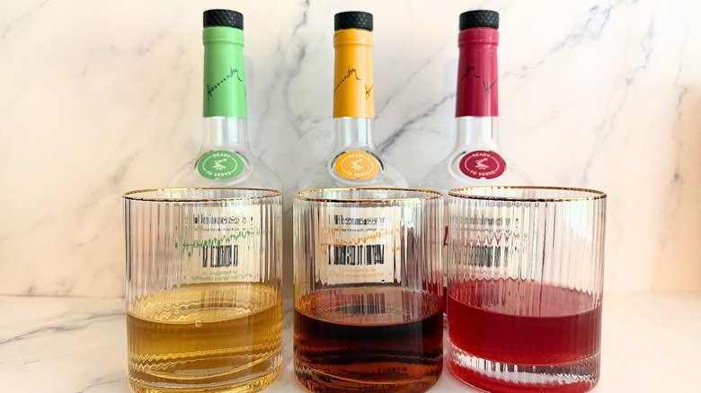 Three Hennessy Very Special Cocktails in glasses, bottles behind