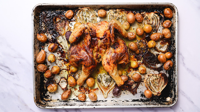 Herb roasted spatchcock chicken on baking sheet