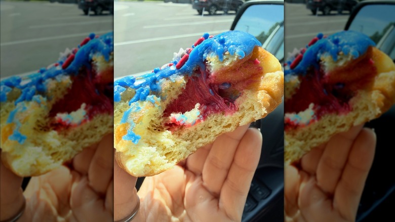 Hand holding Dunkin' Rocket Pop Donut in car