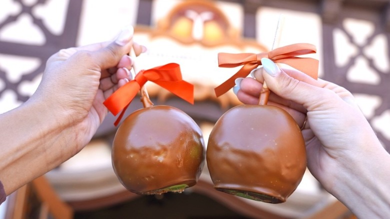 People cheersing with caramel apples in front of Germany's Karamell-Küche