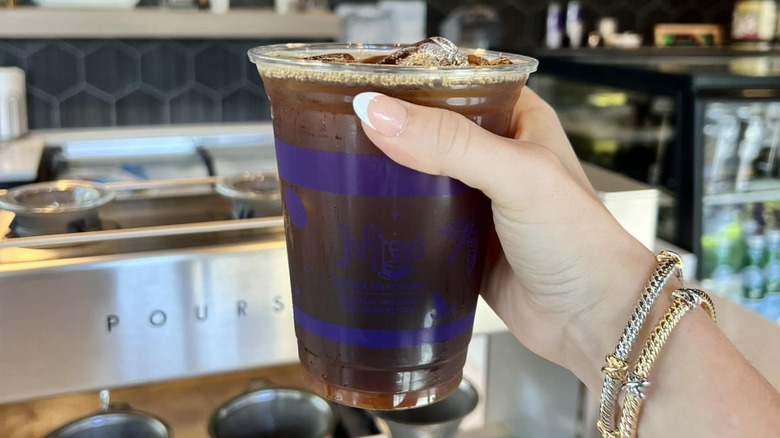 Hand holding a Joffrey's Cold Brew in a plastic cup