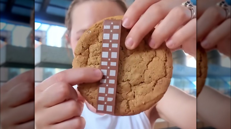 Person holding up a Wookiee Cookie with its distinctive chocolate sash