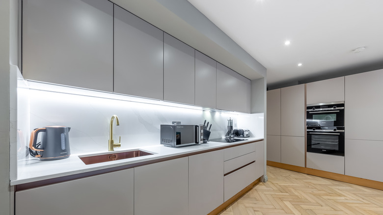 A sleek galley kitchen with slim, gray inset cabinetry