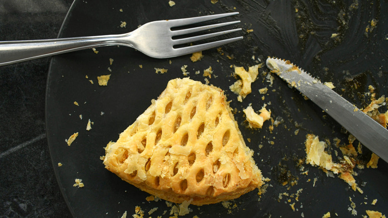 Slice of leftover pie on plate with cutlery