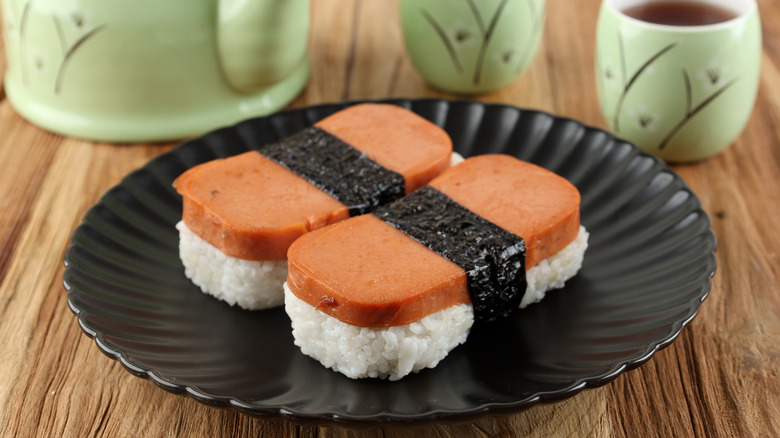 Two pieces of Spam musubi on black plate