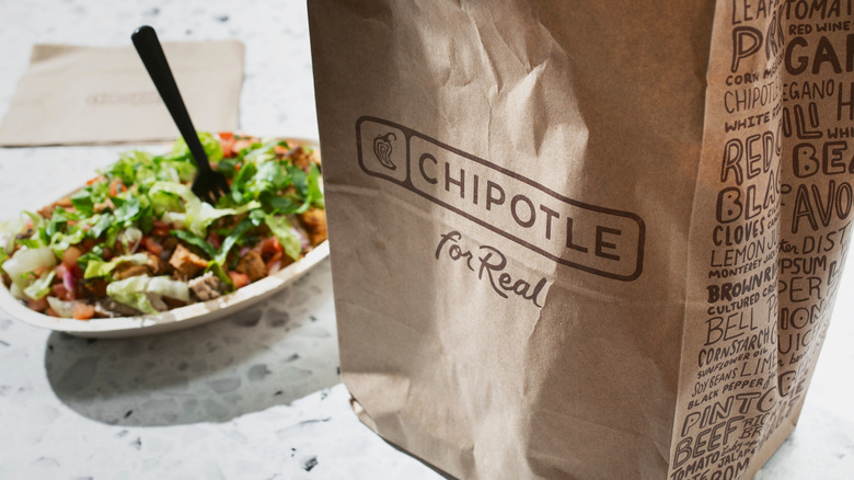 Chipotle takeout bag beside a bowl