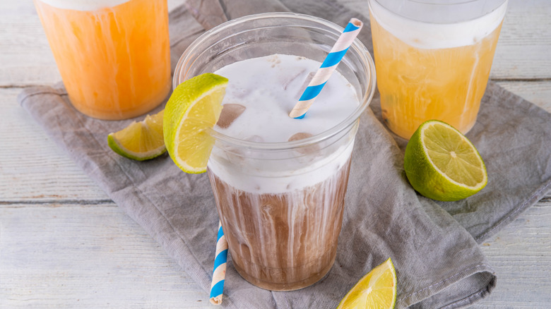 Striped straw in dirty soda with lime wedge