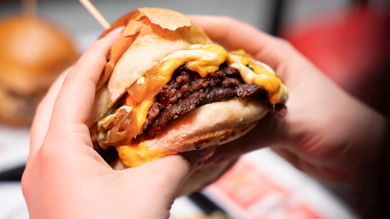Hands holding a smash burger