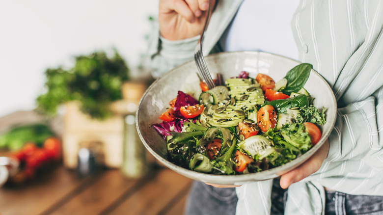A person holding a salad bowl