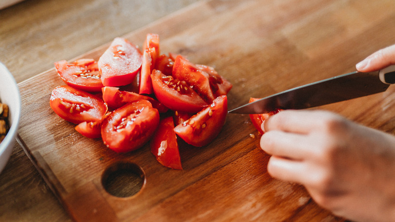 Woman cutting tomatoes on chopping board