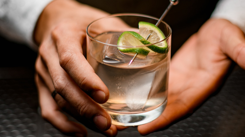 bartender serving drink in rocks glass