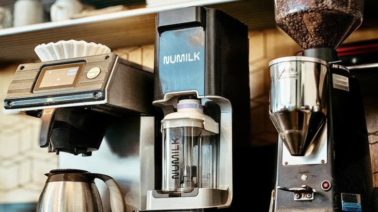 Numilk machine in a cafe with coffee maker and grinder