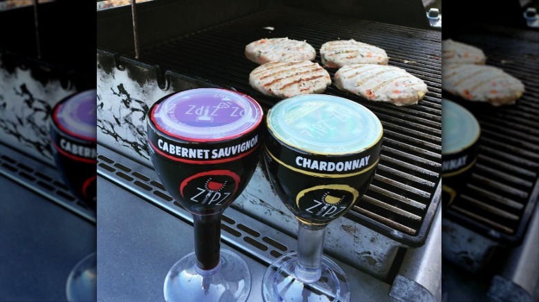 Zipz Wine containers in front of a grill with burgers