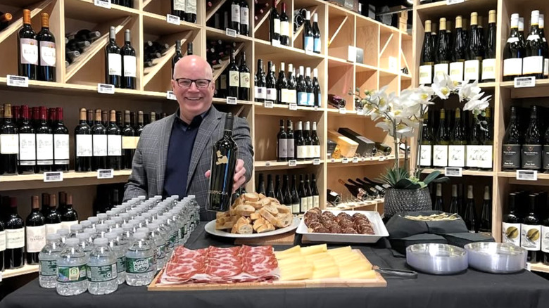 Andrew McMurray smilling in wine cellar with charcuterie and water bottles