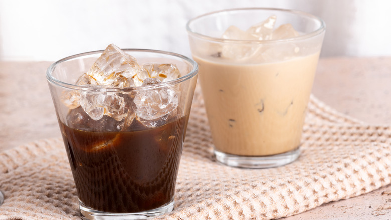 Glass of milk-steeped cold brew coffee against a black background