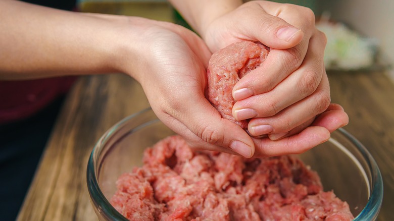 hands mixing ground meat