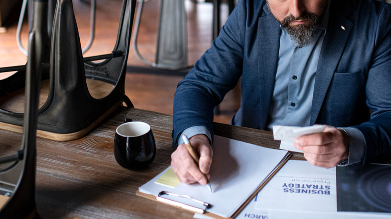 Restaurant employee tallying numbers after close