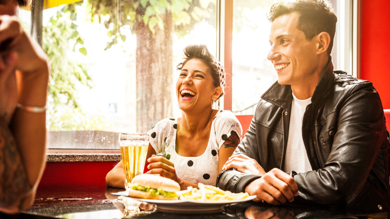 1950s-styled man and woman at a diner table