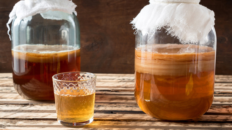 kombucha beverage in glass and brewing in jar