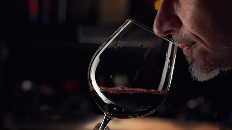 man smelling wine in glass
