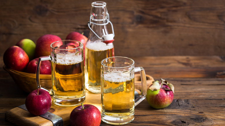 Two steins of cider with apples