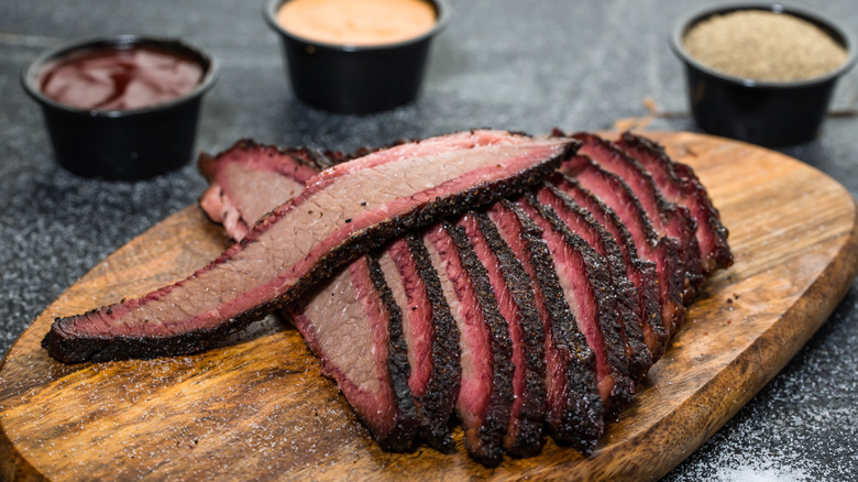 thin and long slices of perfect brisket with pink smoke ring and dark bark exterior