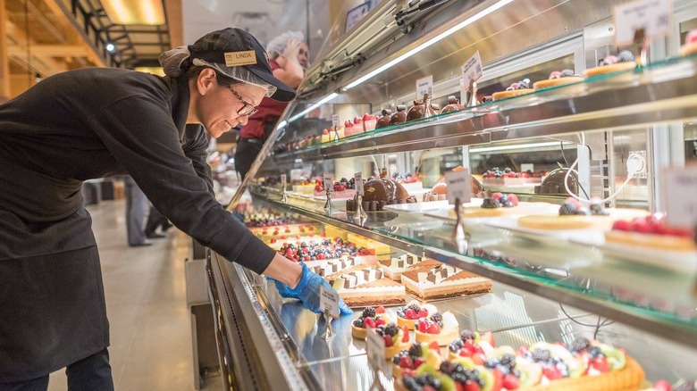 Wegmans bakery worker stocking the bakery refrigerator with pastries