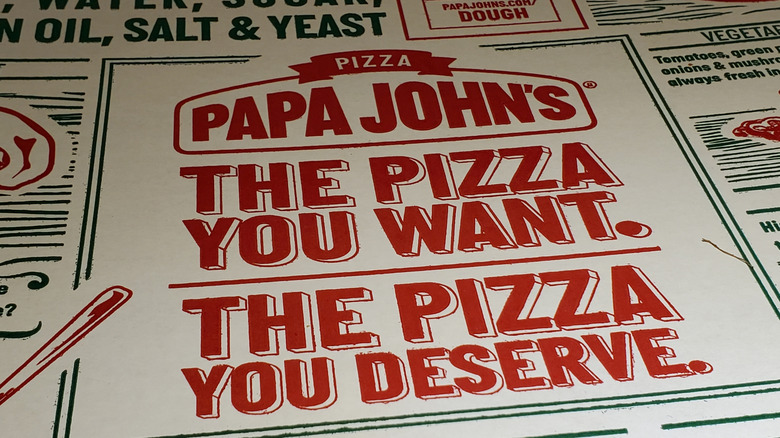The writing on a Papa John's branded pizza box, reading: "The Pizza Y You Want. The Pizza You Deserve."