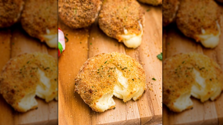 Breaded fried Babybels on cutting board