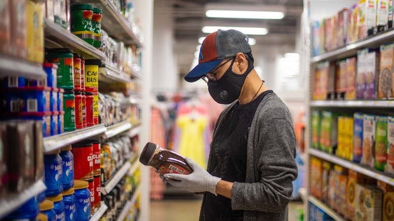 Masked man looking at labels