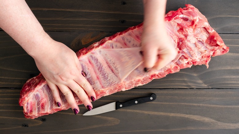 person removing rib membrane