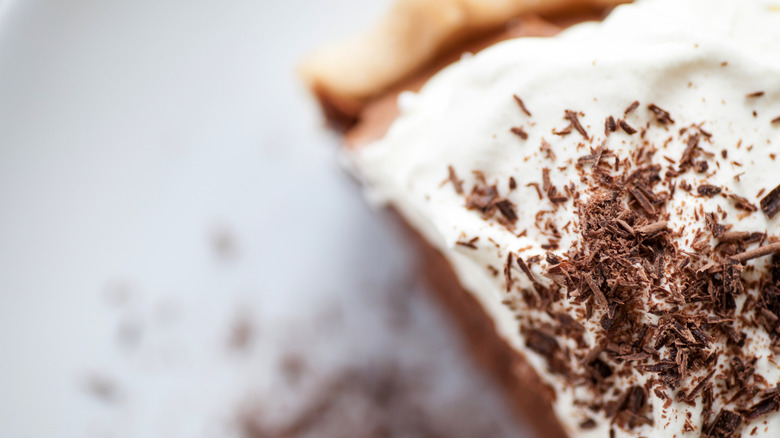 Extreme close-up of chocolate pie with whipped cream topping and chocolate shavings