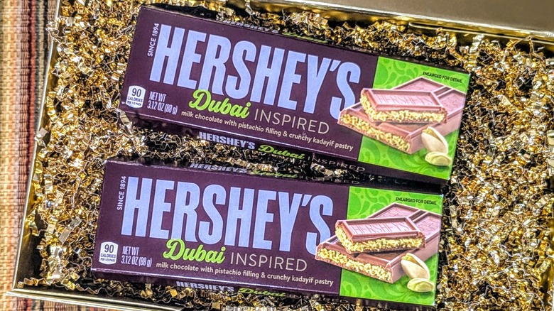 Two Hershey's Dubai-Inspired Chocolate Bars in a gold box with gold crinkle paper