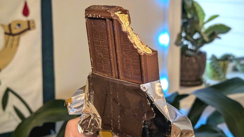 A half-unwrapped Hershey's Dubai-Inspired Chocolate Bar with a bite taken out of it