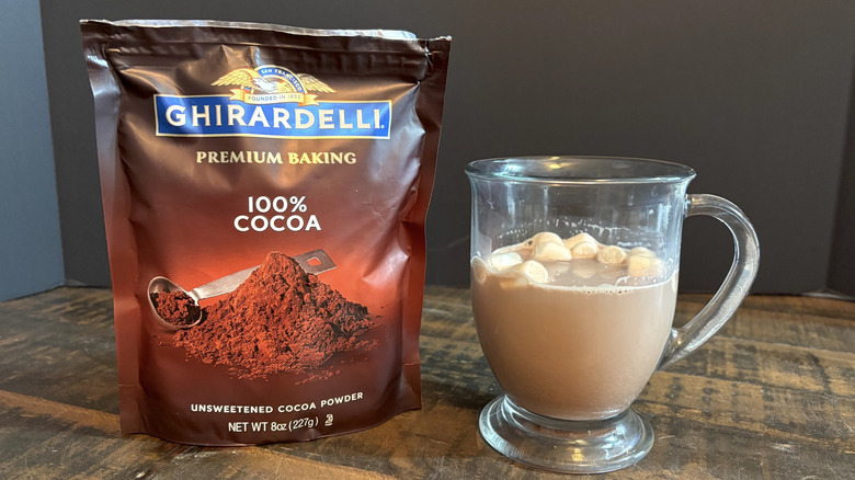 Ghirardelli cocoa powder hot chocolate in glass mug on wooden table