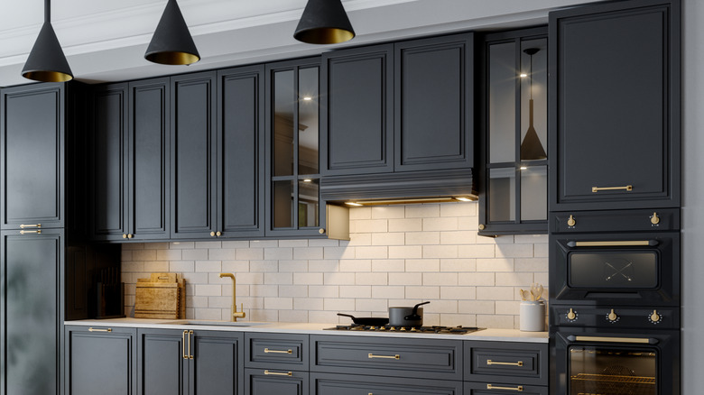 Kitchen with black cabinetry and white tile backsplash