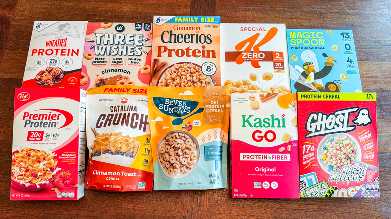 Boxes of protein cereal are laid out on a wooden table.