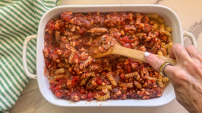 hand stirring pasta bake