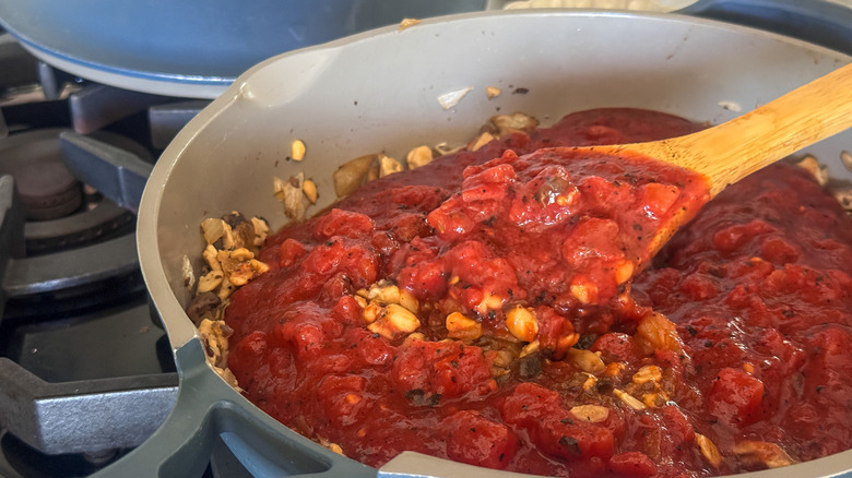 wooden spoon stirring sauce
