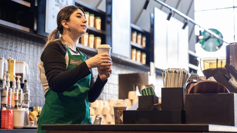 Starbucks barista holding a cup of coffee