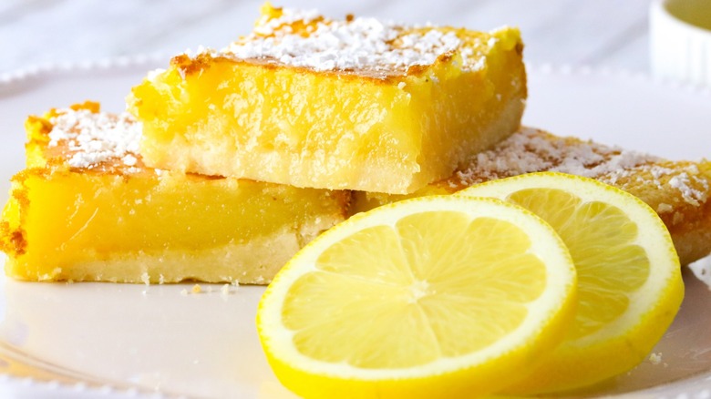 A stack of lemon bars and fresh lemon slices